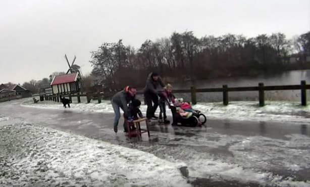 Ice skating and beer crate curling on frozen Dutch roads