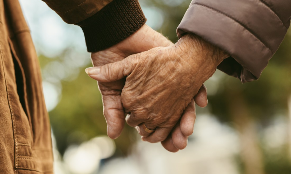 Elderly couple holding hands 